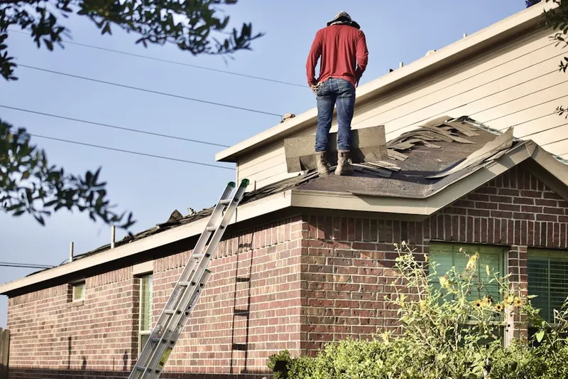 Professional roofer working on a residential roof in Fort Scott